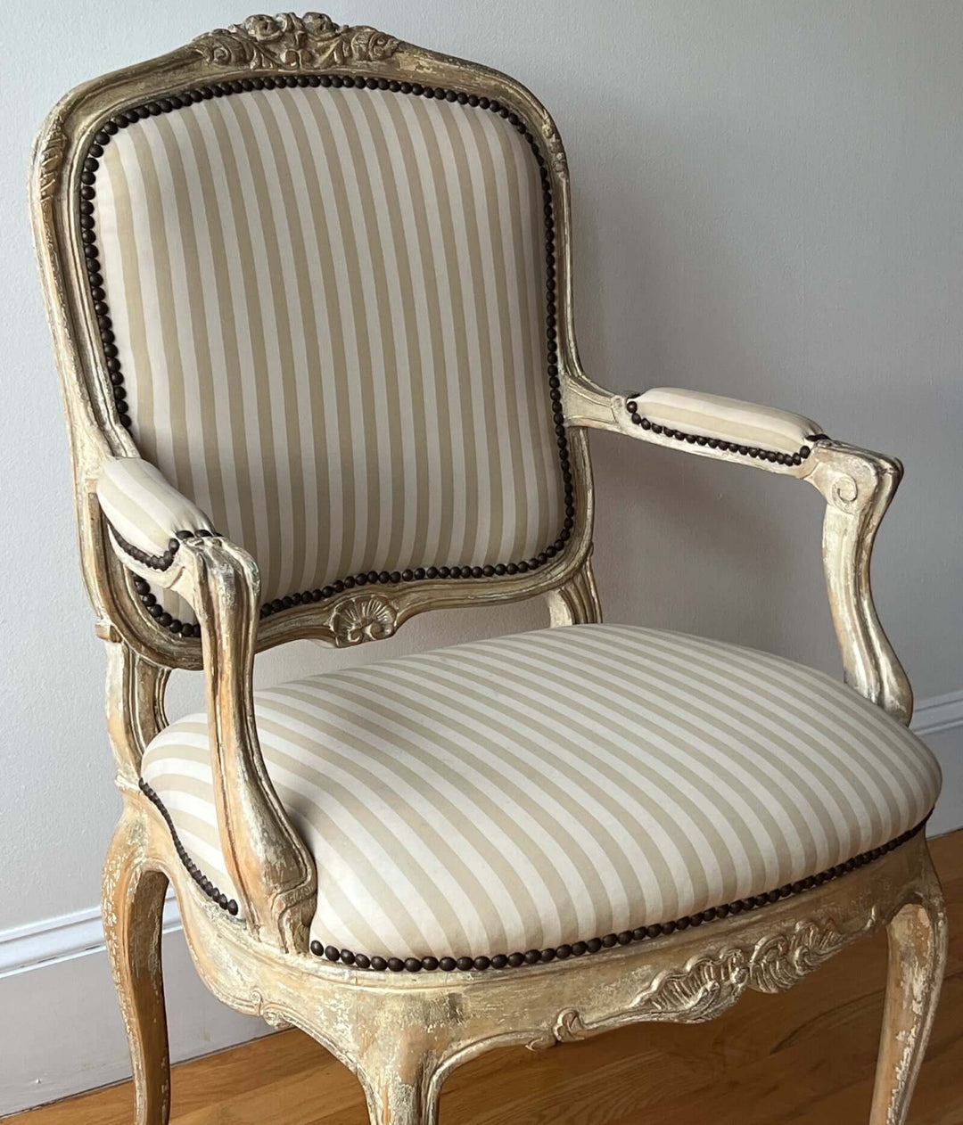 Pair of Vintage Louis XV Style Fateuil armchairs with striped upholstery and carved details.