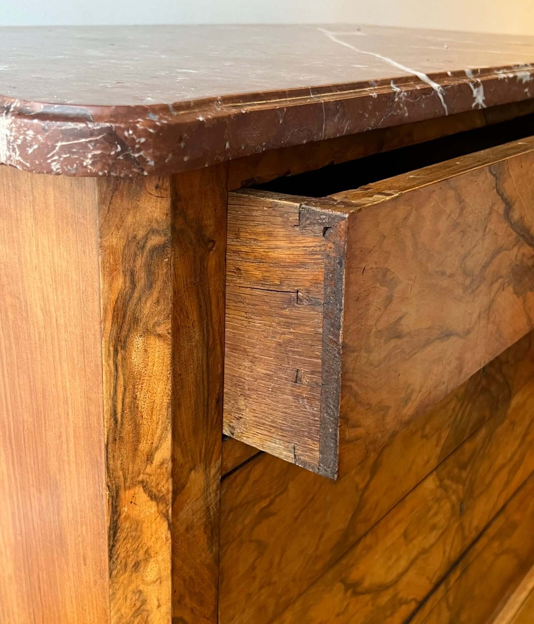 Close-up of 19th-century French Louis-Philippe Marble-top Commode showing Rouge-Royal marble and dovetail joinery.