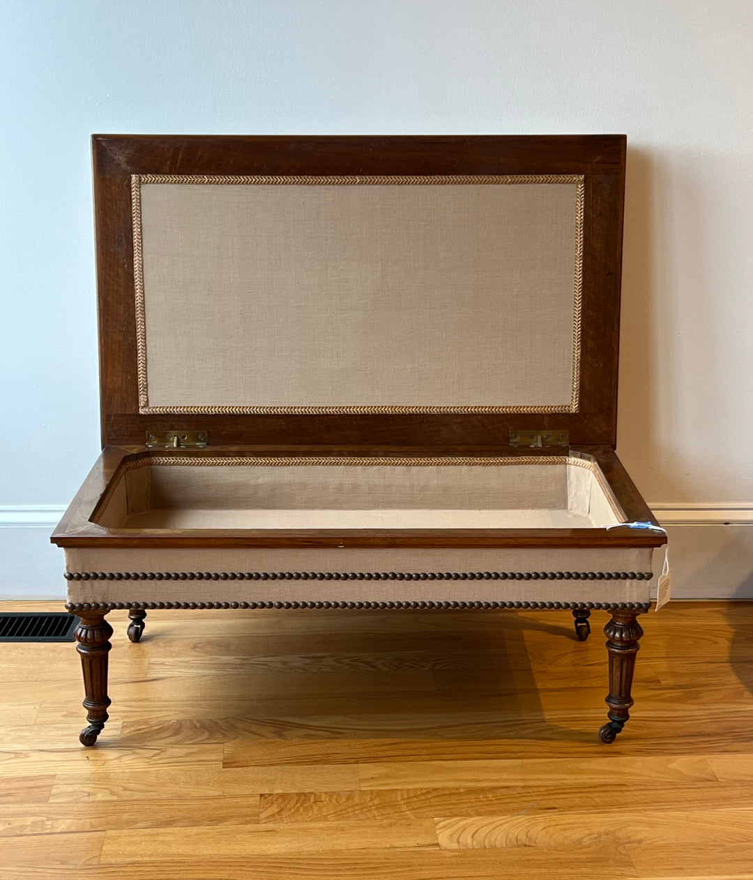 Antique English Tufted Storage Bench on Fluted Legs with Casters with hinged lid open, revealing lined interior.