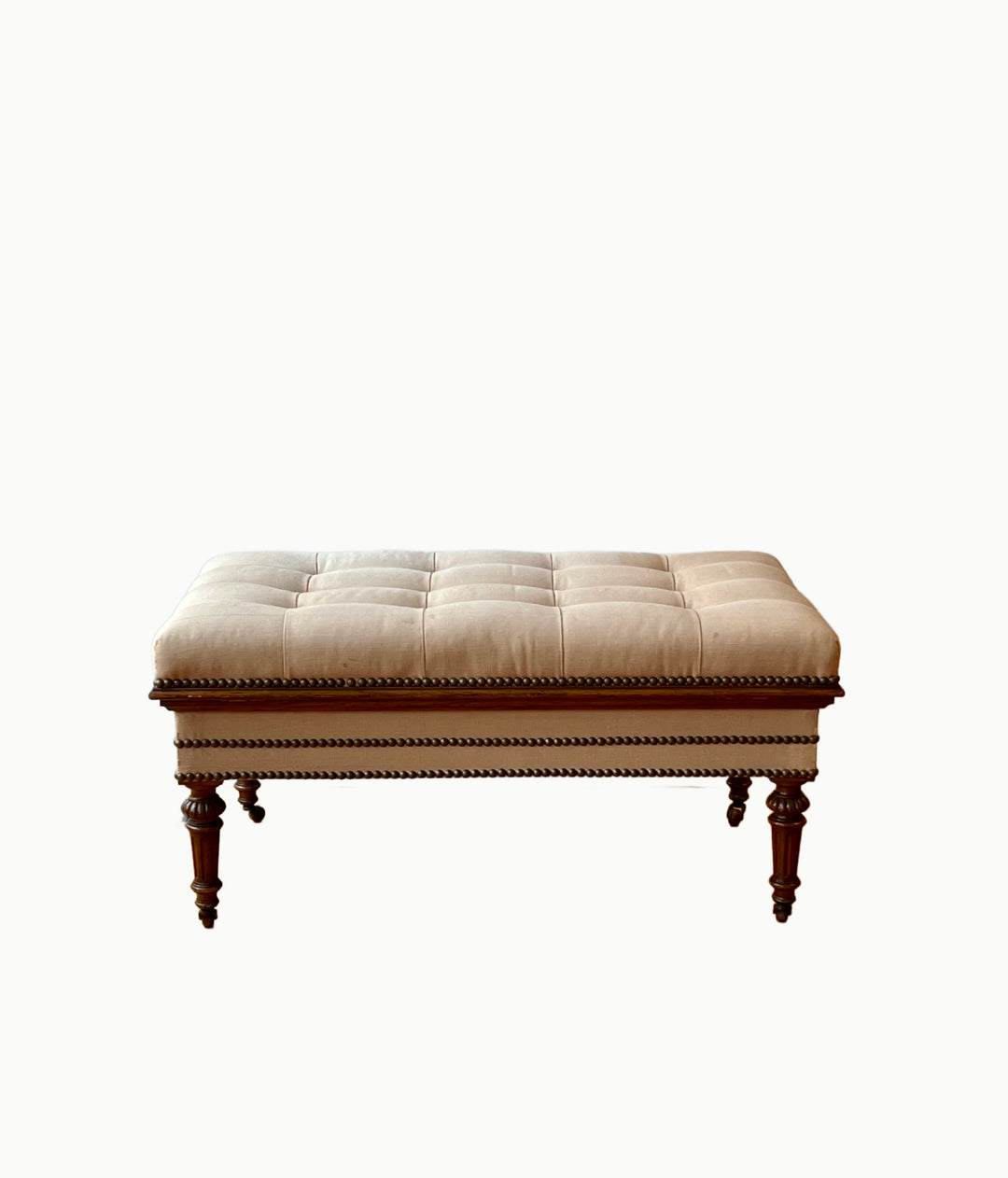 Antique English Tufted Storage Bench on Fluted Legs with Casters featuring tufted upholstery and elegant legs.