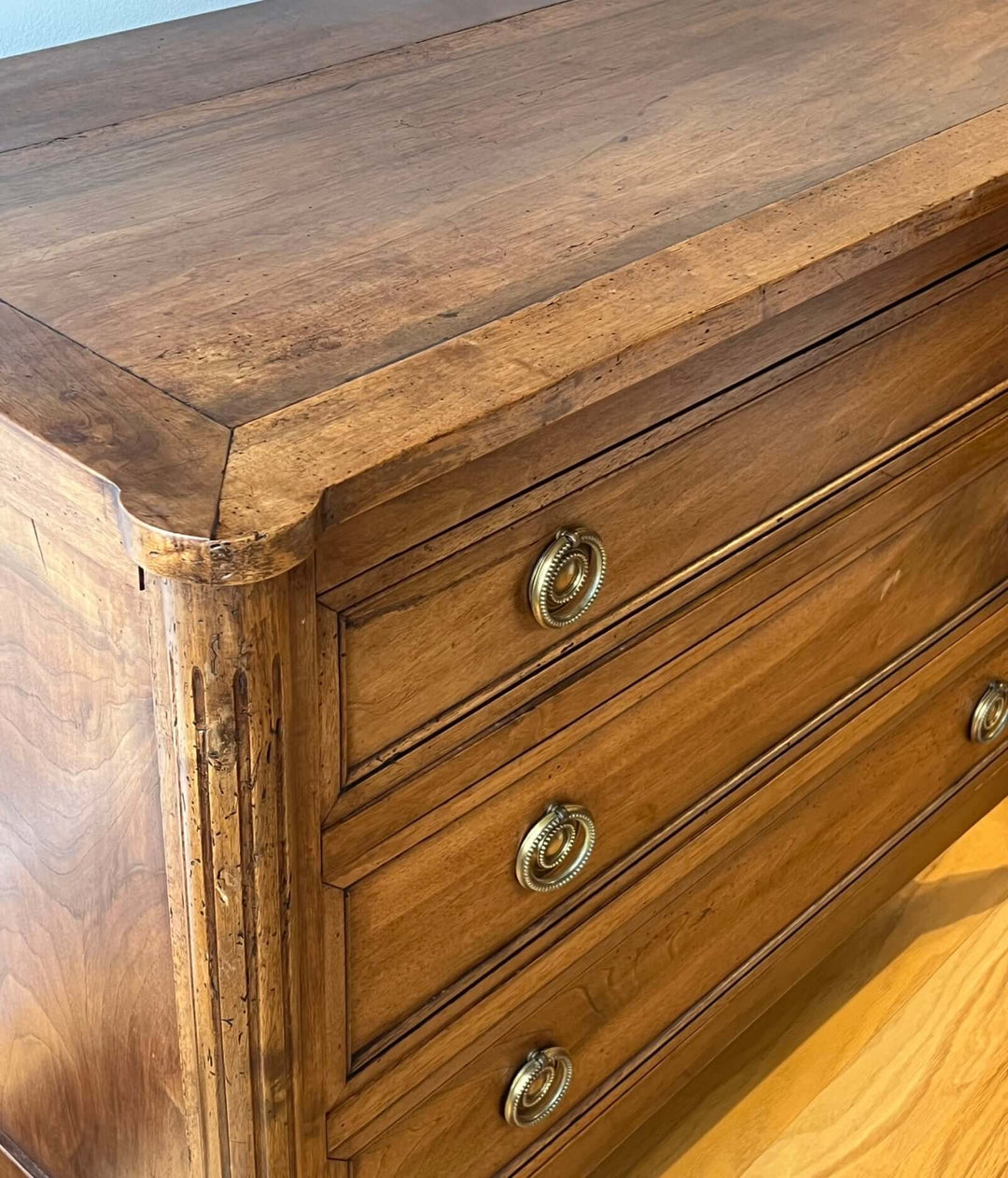 Early 19th Century French Louis XVI Style Walnut Three-Drawer Commode with fluted stiles and brass-ring pulls.