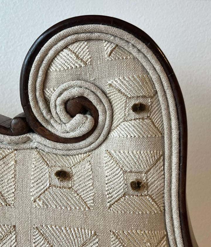 Detail of the Antique Scroll-Crest Upholstered Armchair in Mahagony Frame, showcasing the scroll design and upholstery.