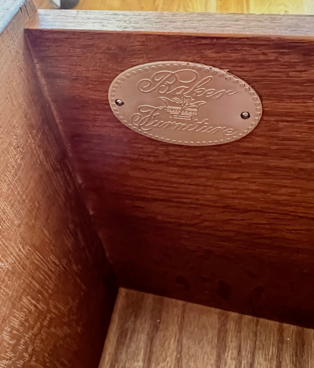 Wooden furniture with 'Baker Furniture' logo on a wooden surface