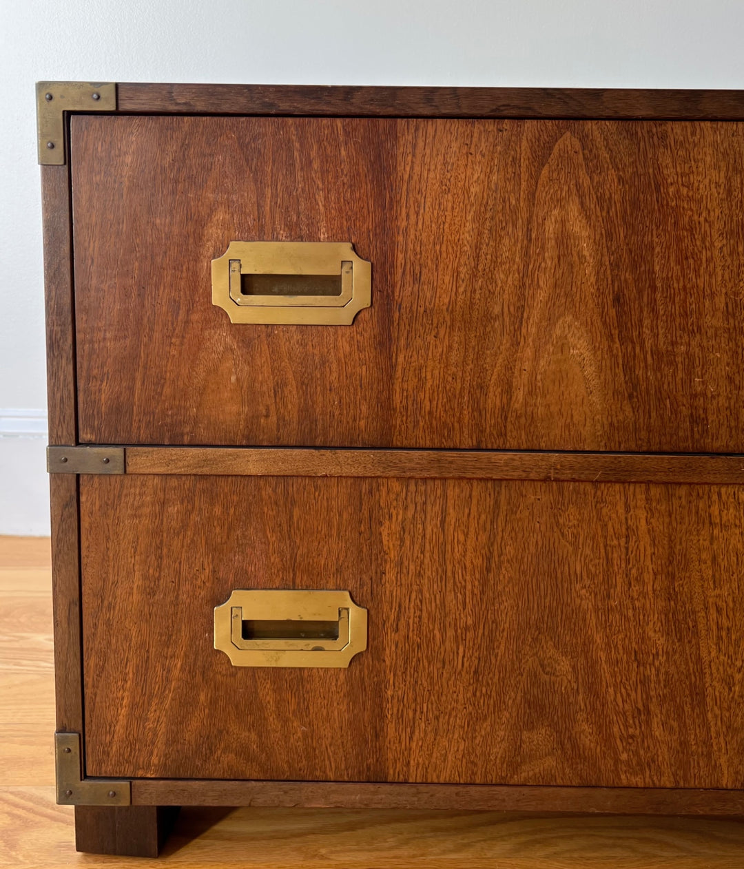 Wooden chest with brass handles on a wooden floor.