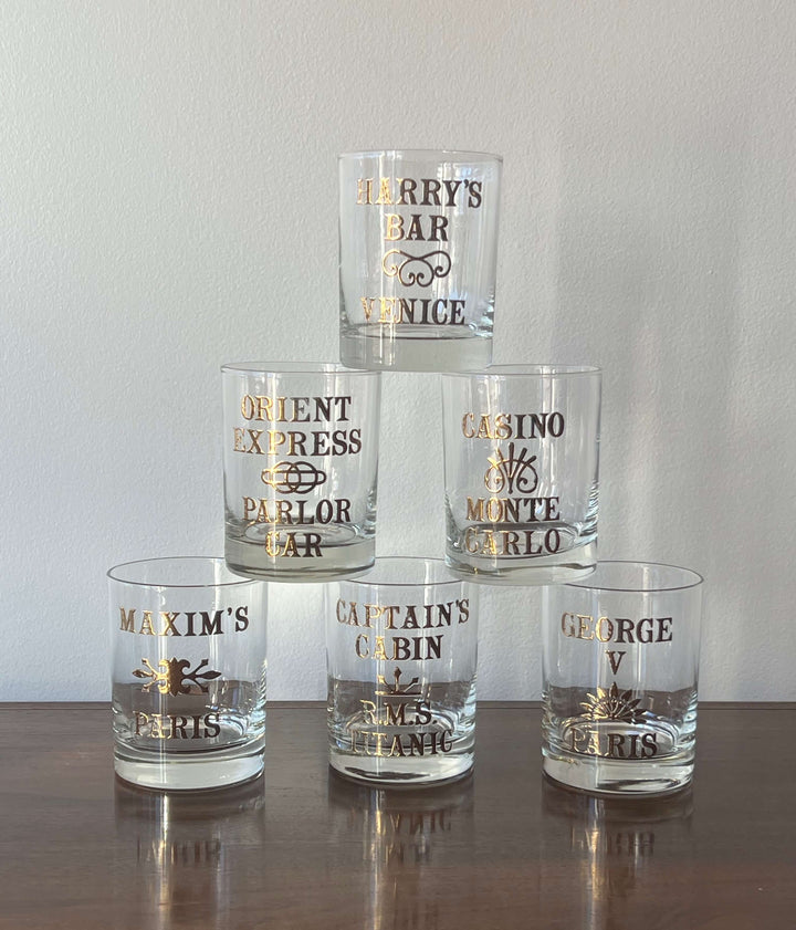 Vintage set of Six Cera "World Famous Bar Glasses" with 22K Details, featuring iconic bars in gold lettering.