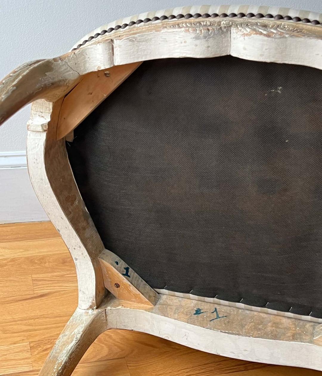 Pair of Vintage Louis XV Style Fateuil armchairs showing the detailed wooden frame and upholstery underside.