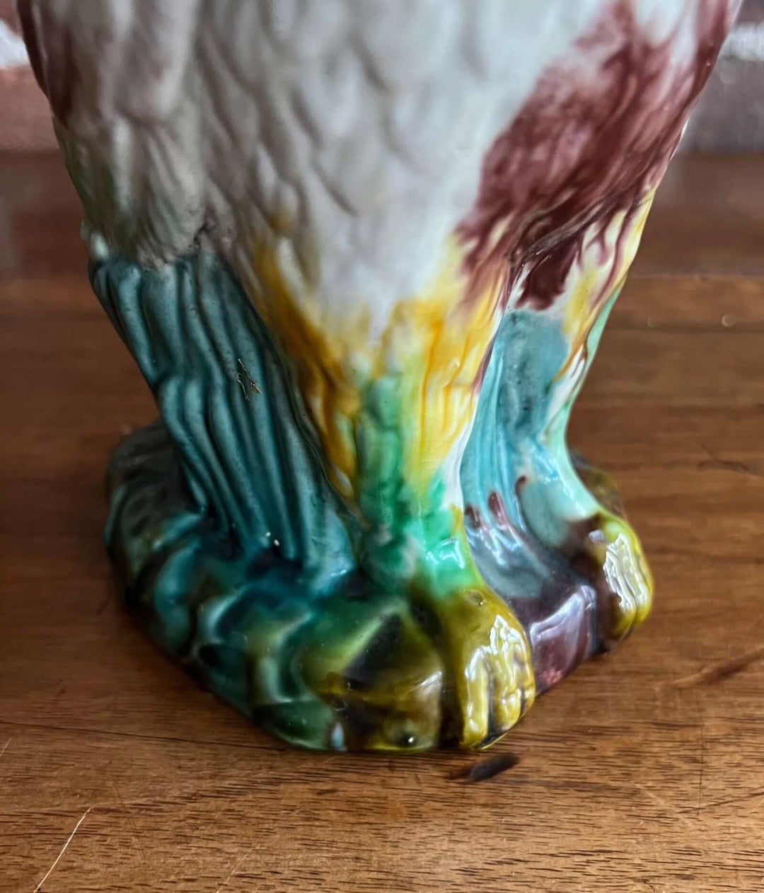 Vintage Majolica Cockatoo Pitcher showcasing colorful glaze and detailed feather texture on the base.