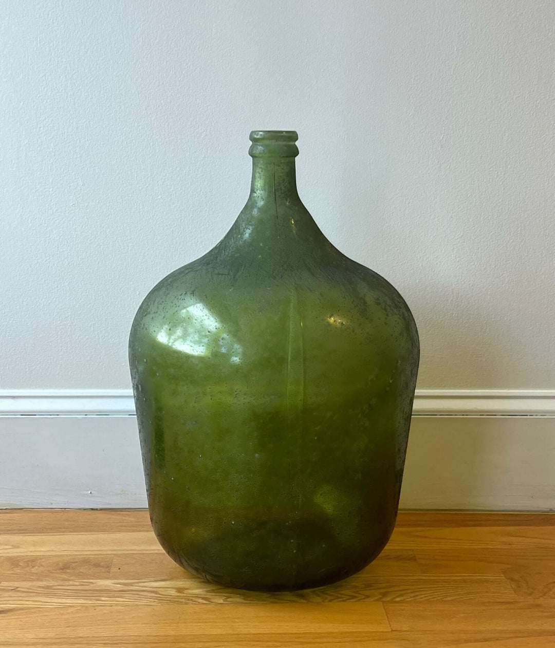 Vintage Spanish Green Demijohn Bottle with Rolled Rim showcasing a textured surface and rich mossy green glass.