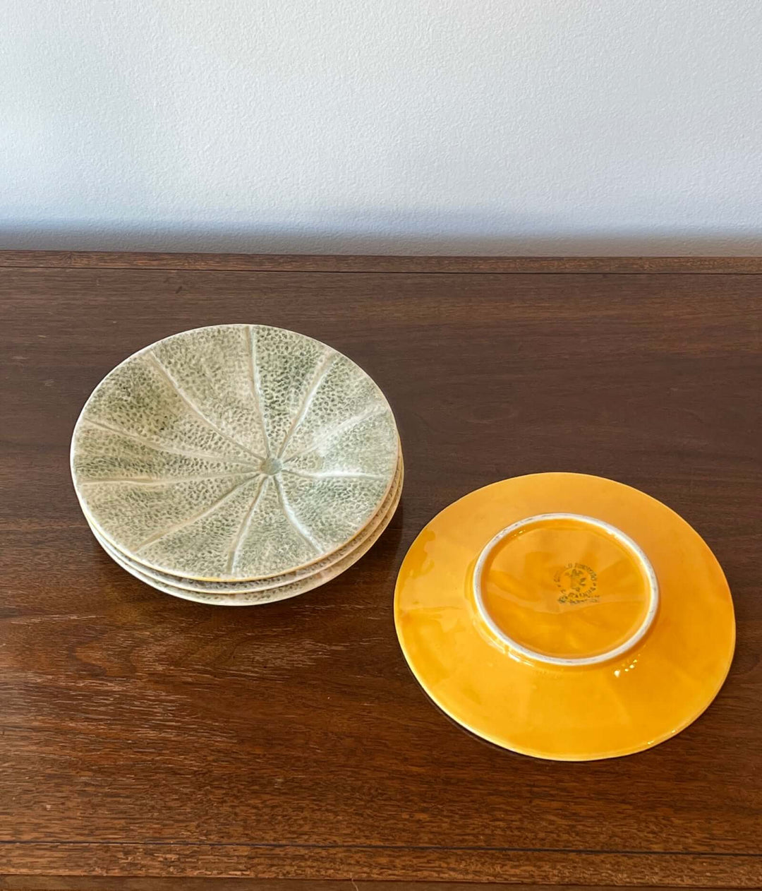 Set of Bordallo Pinheiro Melon Dessert Plates from Portugal on wooden table.
