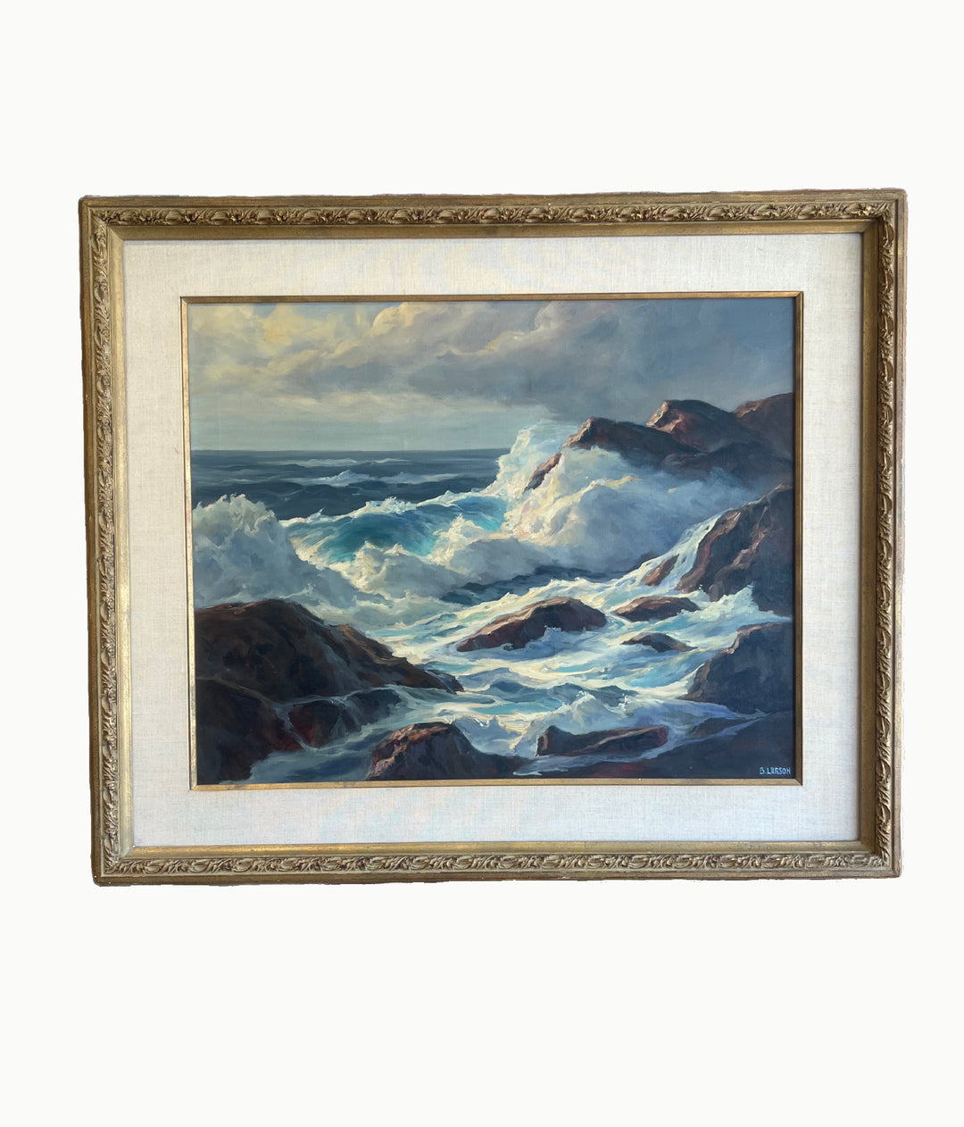 Framed painting of a stormy sea with waves crashing against rocks.