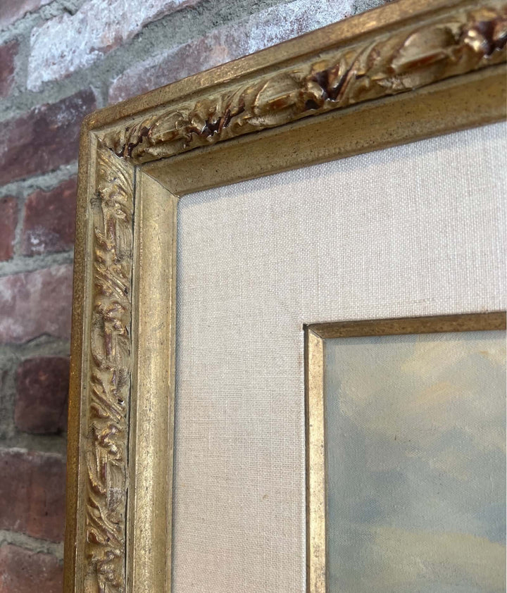 Gold-framed painting on a textured wall