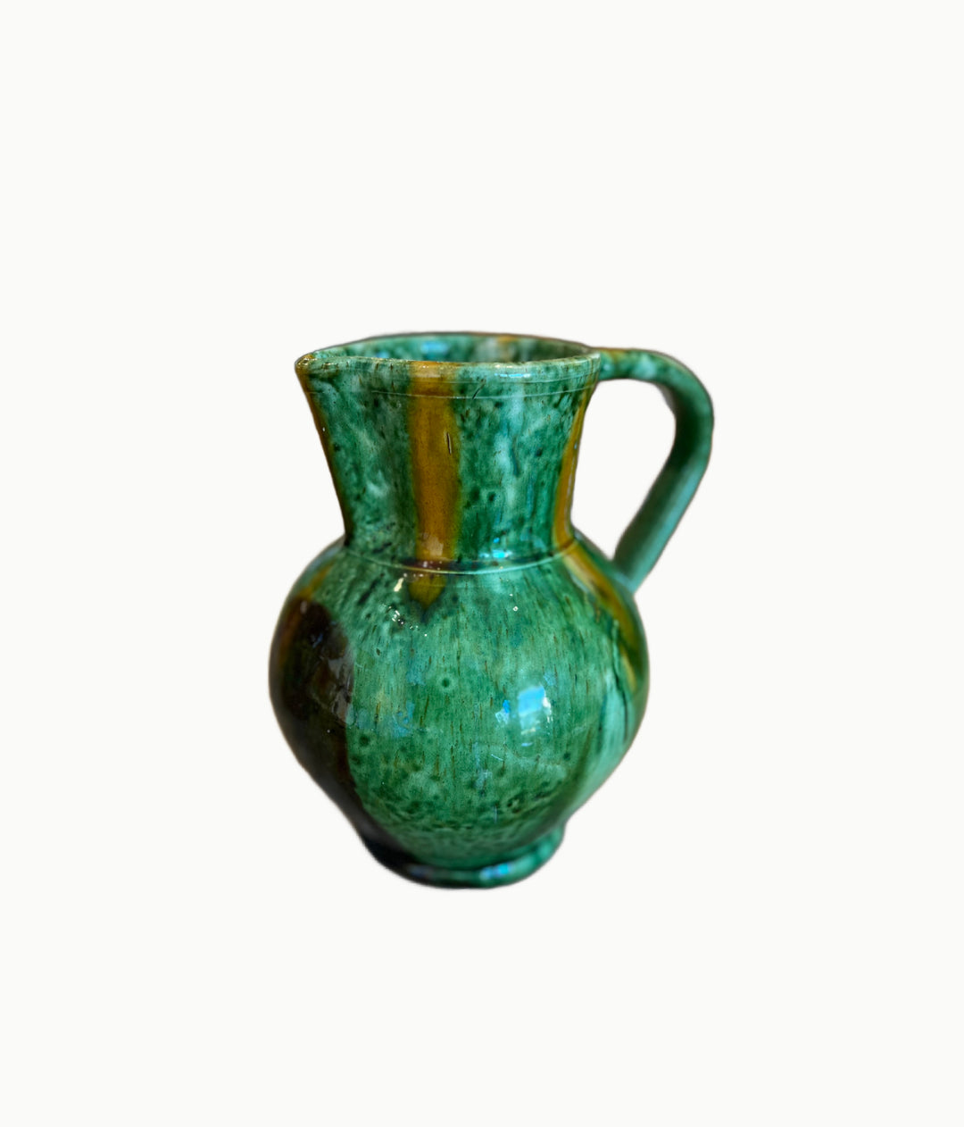 Green ceramic pitcher on a white background