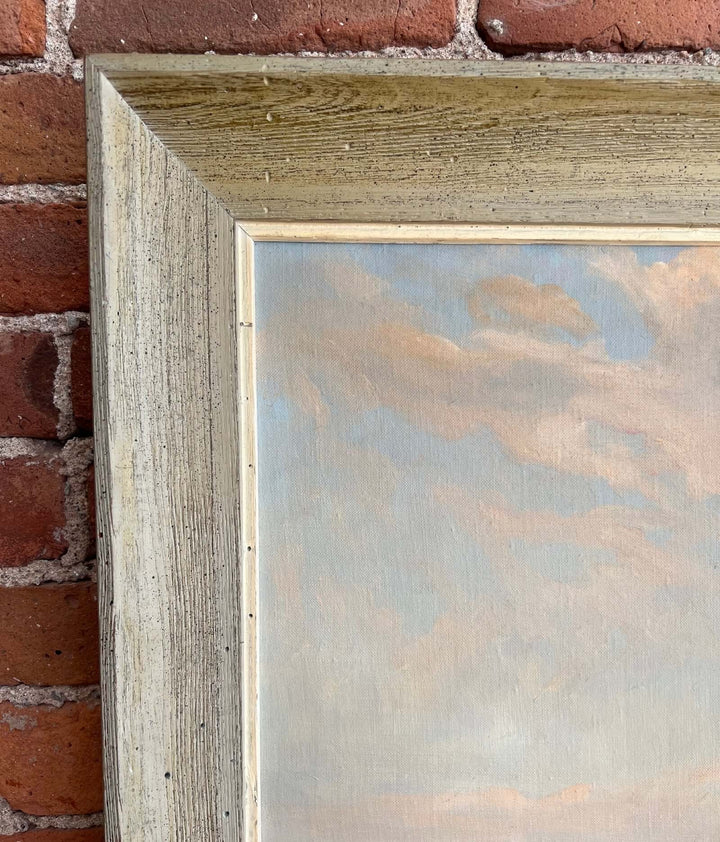 Framed painting leaning against a brick wall