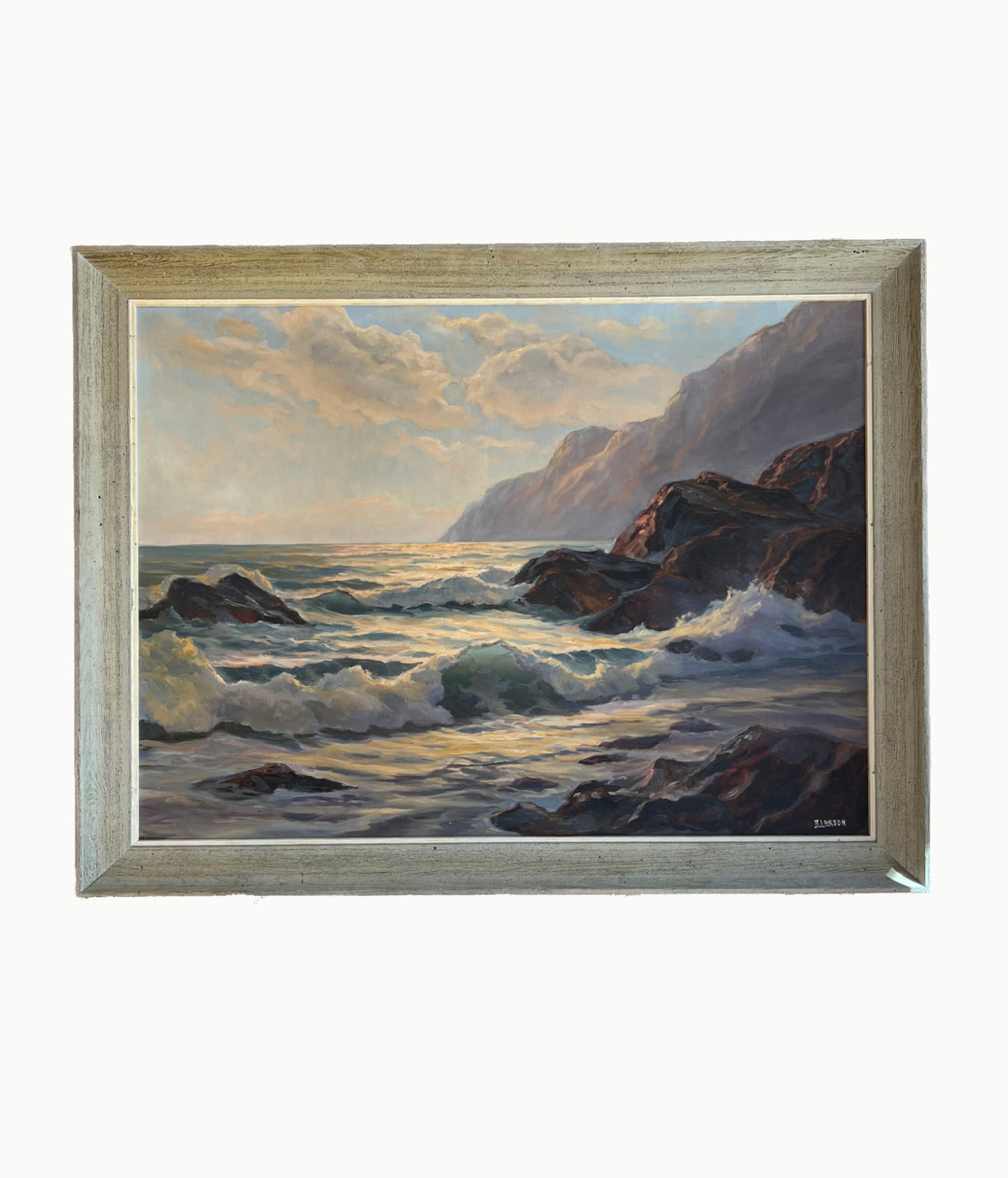 Framed painting of a coastal scene with waves and cliffs.