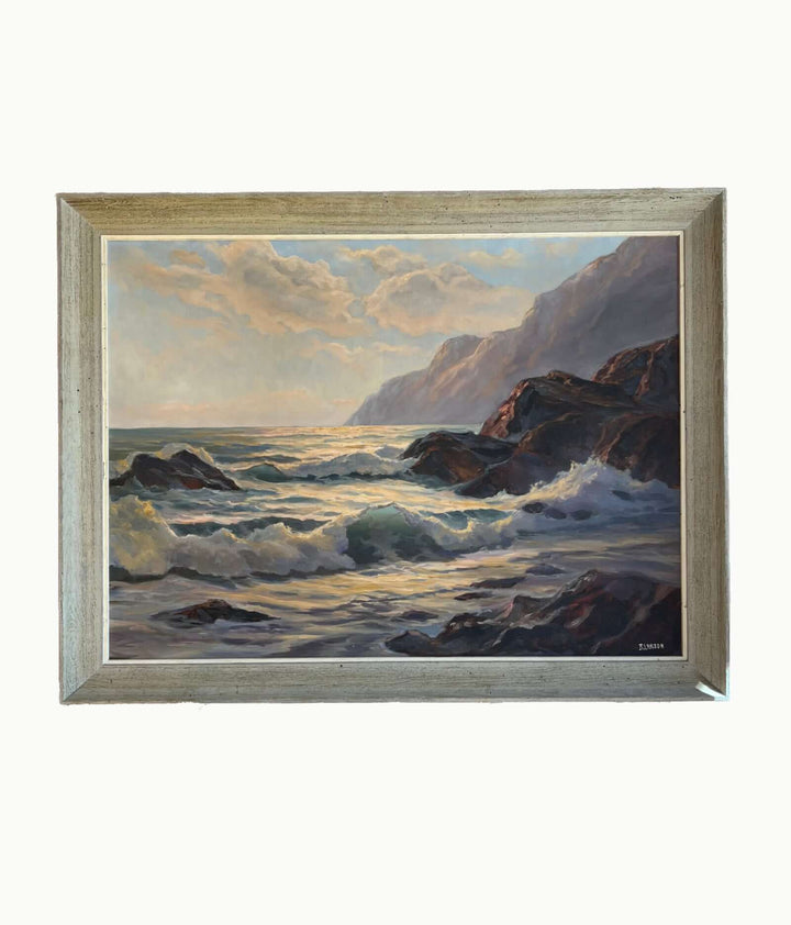 Framed painting of a coastal scene with waves and cliffs.