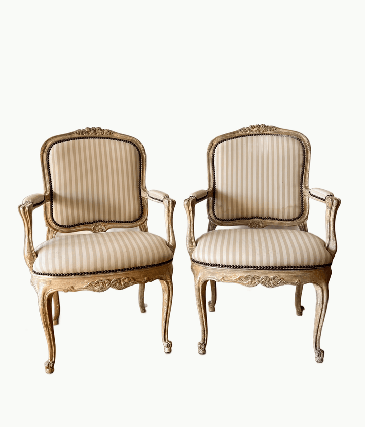 Pair of Vintage Louis XV Style Fateuil armchairs with striped upholstery and carved details.