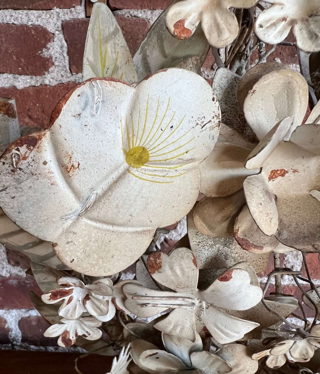 Pair of Vintage Italian Tole Floral Candelabras featuring hand-painted metal flowers in soft ivory and yellow.