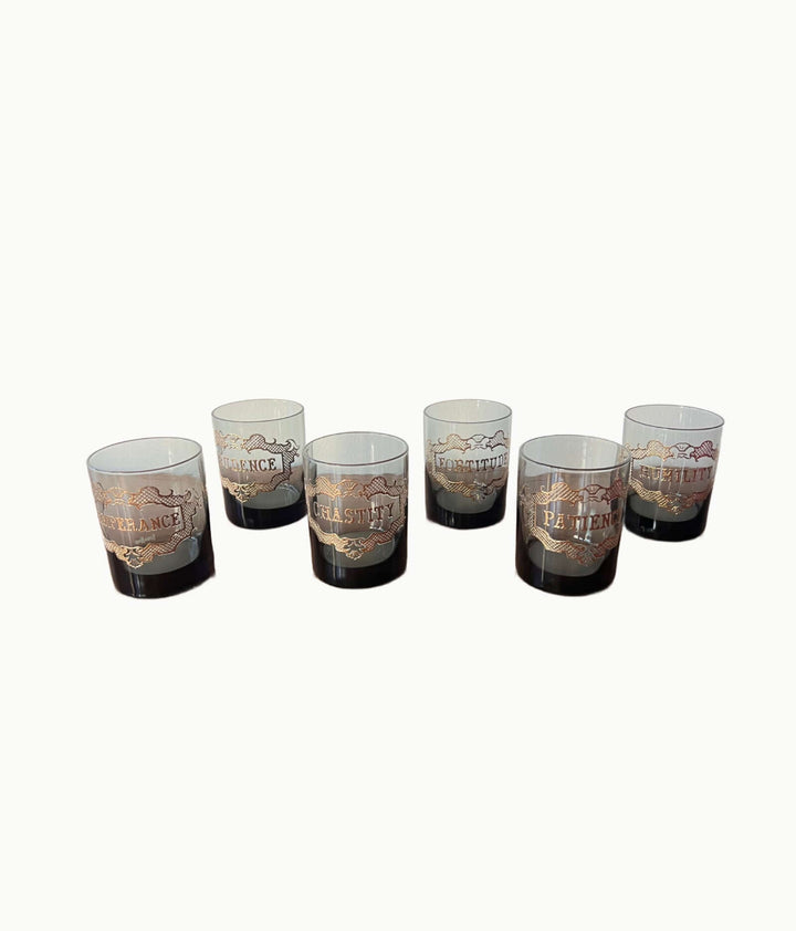 Set of six glass tumblers with printed designs on a white background