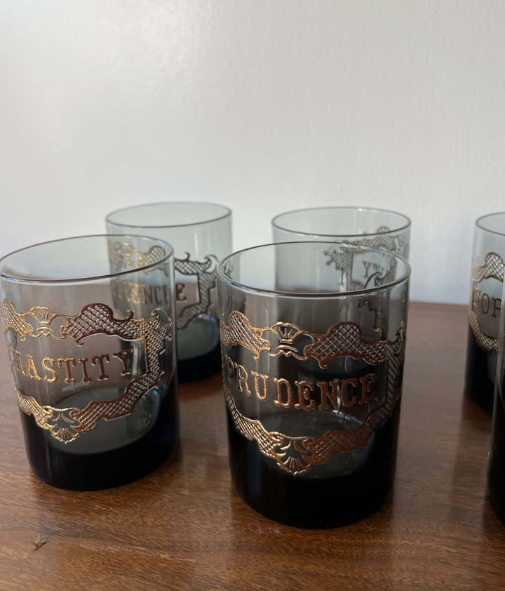 Set of glass tumblers with engraved text on a wooden surface